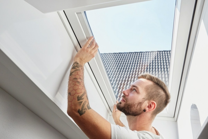 Homme regarde ouverture store plissé